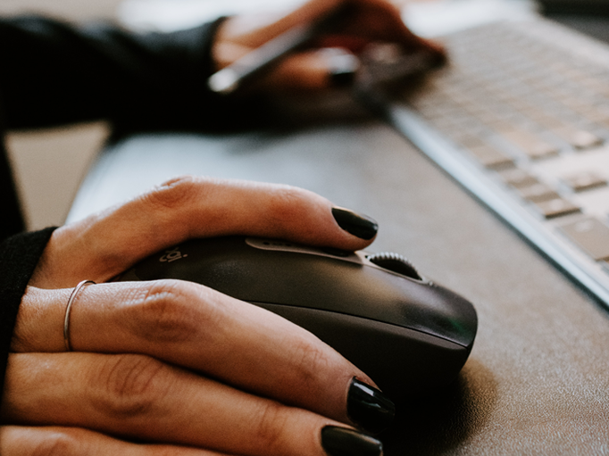 A woman using a computer mouse to navigate software